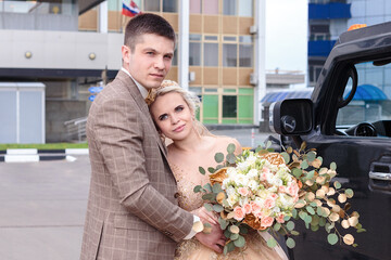 A young couple is walking around the city. The bride and groom are walking.