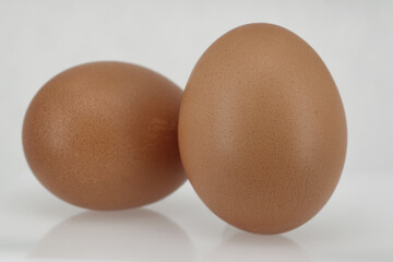 Close-up of two brown chicken eggs isolated on white background.