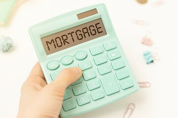 Mortgage pre-approval, calculator with pre-approval text in hands on a light background