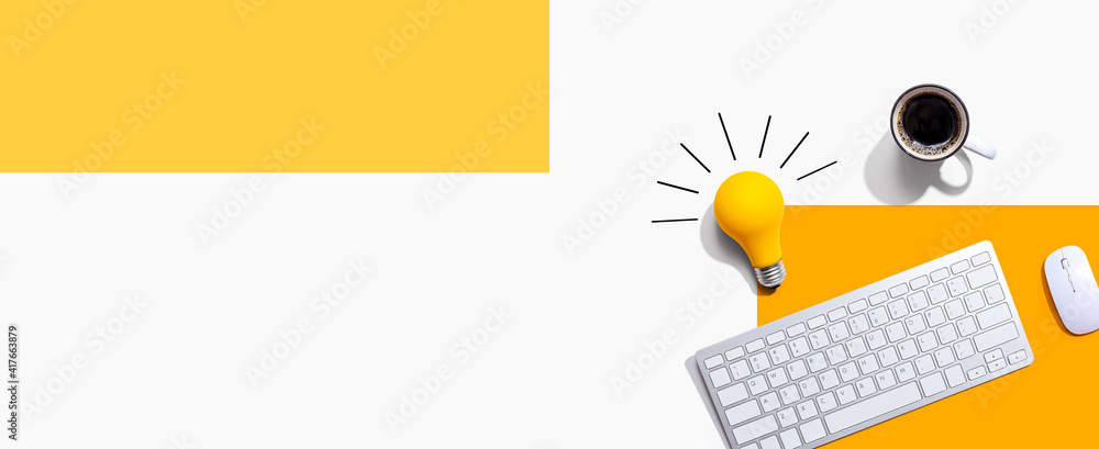 Poster computer keyboard with a yellow light bulb from above