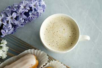 Vanilla and pistachio eclairs on wooden board on table