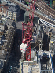 Naklejka premium aerial view of a tall building seen from above showing tower crane 