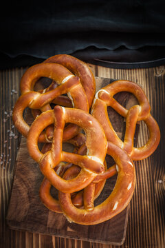 Stack of freshly baked pretzels on a wooden chopping board