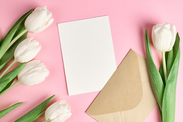 Greeting card with copy space and white tulip flowers bouquet on pink paper background