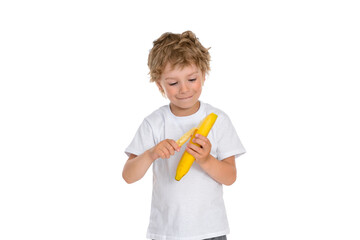 A little boy peels a ripe banana.