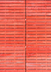 Red wall decking with wooden boards of pallets. Hipster decor. Wooden plank background
