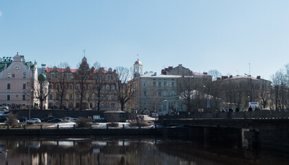 Fototapeta premium Beautiful houses and a bridge over the river. Vyborg city, Russia. The oldest city that used to belong to Finland and Sweden. Bridge over the river. Beautiful architecture and outbuildings.