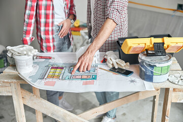 Male hand pointing at the layout of a building