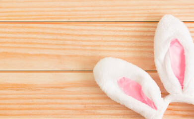 Symbol of Holy Easter. White bunny ears on a light wooden background. Top view. Copy space. Easter background. Background for design.