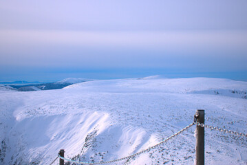 mountains in winter, view from above, winter panorama, mountain trail at sunset, Polish mountains "Sniezka", National Park, railing on the mountain trail