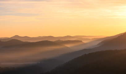 sun rays lighting a foggy valley during sunrise