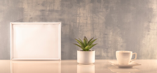 Modèle de cadre photo blanc avec espace vide pour logos, inscription publicitaire. Cadre en mode paysage sur un espace de travail avec une tasse. Ambiance zen.	