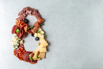 Italian appetizers or antipasto set with gourmet food on a light background, top view. Mixed cheese...