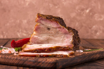 A piece of baked meat with layers of bacon, cut from the bottom of a pork carcass, along with the...