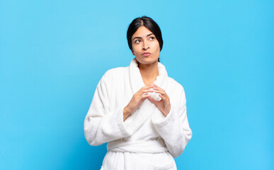 young hispanic woman scheming and conspiring, thinking devious tricks and cheats, cunning and...
