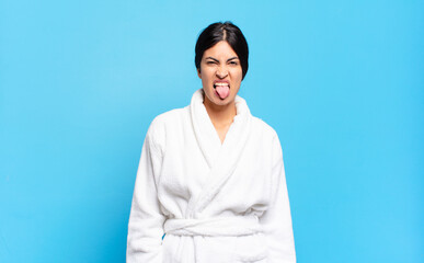 young hispanic woman feeling disgusted and irritated, sticking tongue out, disliking something...