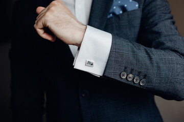 Close up of businessman wearing cufflinks. Elegant young fashion business man wearing suit.
