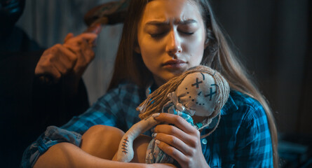 a frightened girl embraces a toy and a maniac is behind her . concept