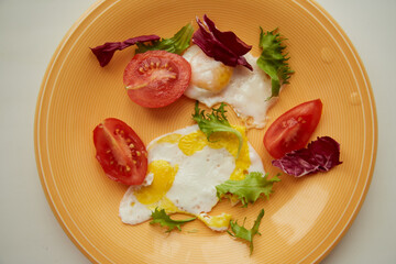 Morning meal with bright products: equal eggs, tomato and salad