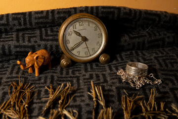 Still life with antique clock, elephant figurine and silver ring