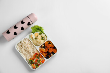 Thermos and lunch box with food on white background, top view