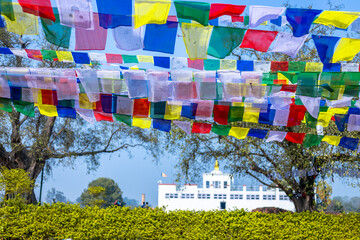 Many prayer flags in the wind against the Holy Maya Devi Temple in Lumbini, Nepal.