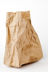 Crumpled paper bag with greasy spots on a white isolated background. Recycling of secondary waste
