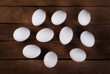 ten white eggs on a wooden rustic background top view