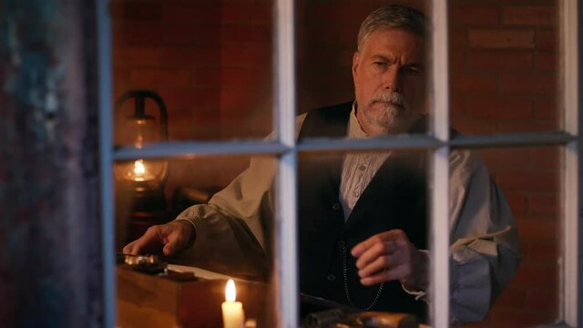 POV thru window 19th century man arms himself after hearing noise