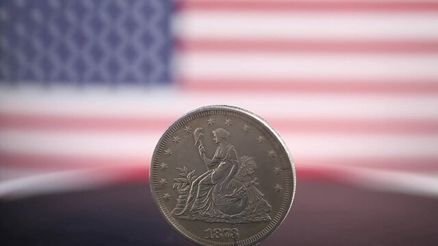 American silver coin rotating on USA flag background