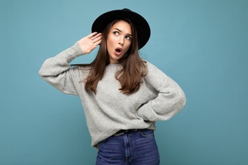 Portrait of young emotional beautiful brunette woman with sincere emotions wearing stylish grey...