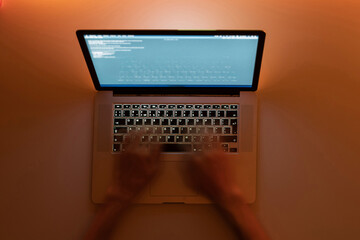 working late in the night, hands typing text on a laptop keyboard, motion blur effect