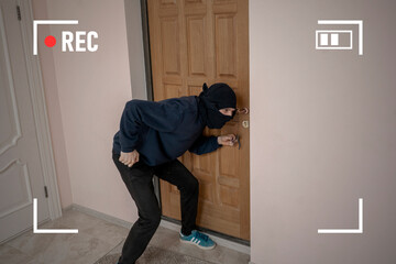 the crime burglar in black mask try to break door on house apartments, the secret cctv camera system