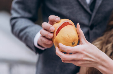 the bride and groom are holding halves of a grapefruit