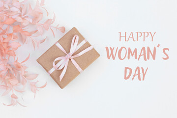 Happy Women's Day text , pink flowrers and a gift box on white background. Happy Women's Day  background.