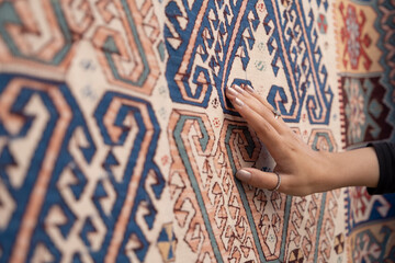 Young woman touching the traditional turkish carpet.Traditional culture products. - obrazy, fototapety, plakaty