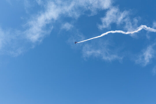Vintage biplane does loop stunt with smoke trails. airplane
