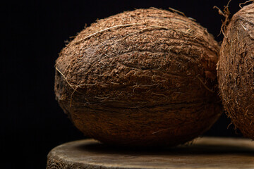 Isolated coconut on a black background. Two whole coconuts on a dark background. Healthy fruit