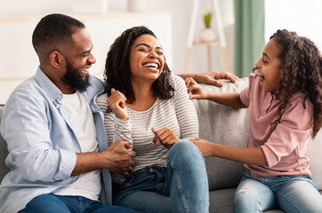 Portrait of a happy black family tickling at home