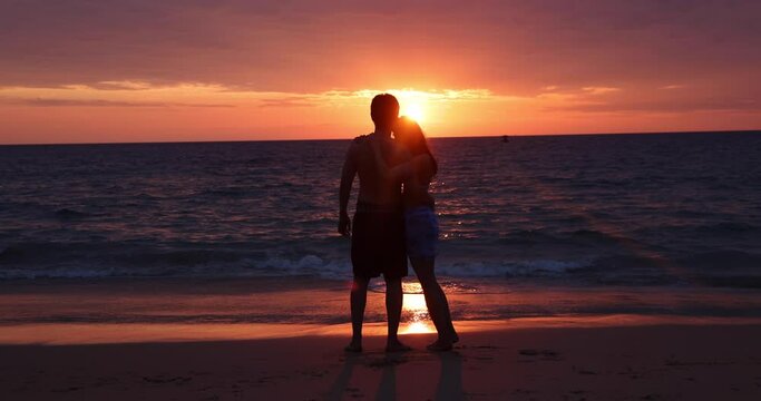 Take a silhouette shot of a teenager, a woman kissing with her boyfriend on the beach, with the golden glow of the evening sun. Concept pictures about love, romance, Valentine, propose. 4K.