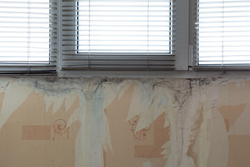 Water marks on the wall under the plastic window. Preparation for the renovation of the apartment.