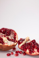 Fresh ripe sliced pomegranate fruit with red seeds isolated on white background