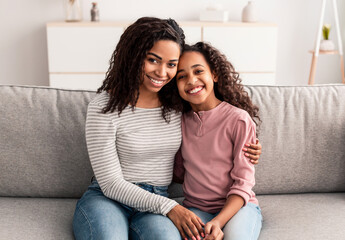 Portrait of black mother and daughter hugging