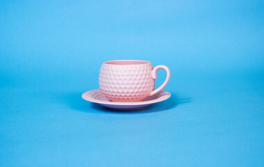 It's coffee time. Pink coffee cup on the table.blue  background.