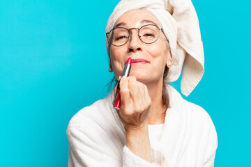 senior pretty woman after shower making up and wearing bathrobe