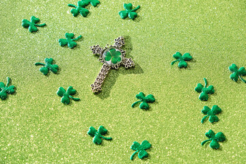 Celtic Cross with Shamrocks leaves - symbol of st.Patrick. shiny green glittering textured background. st. Patrick's day festive concept. 