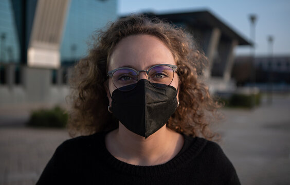 Portrait of a young woman with a black mask on street to prevent the covid 19.