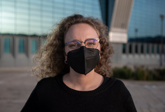 Woman with a black mask to prevent the spread of coronavirus in an urban space.