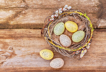Fototapeta na wymiar beautiful nest with easter eggs on old wooden boards. easter background with copy space
