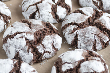 Delicious sweet brownie chocolate chip cookies sprinkled with powdered sugar on craft paper. Homemade baking. Close up.
